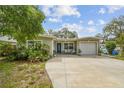 Charming single-story home with a blue front door, a well-maintained lawn, and an attached one-car garage at 6046 River Rd, New Port Richey, FL 34652