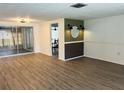 Bright living room with new floors, modern accent wall, and sliding glass doors to backyard at 6108 Maplewood Dr, New Port Richey, FL 34653