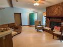 Inviting living room featuring a rock fireplace, ceiling fan, and neutral-toned walls at 7239 Lykes Dublin Rd, Brooksville, FL 34601