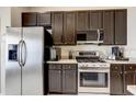 Bright kitchen with stainless steel appliances, dark cabinetry, and ample counter space at 8335 Crescent Moon Dr, New Port Richey, FL 34655