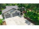 Aerial view of a house featuring a spacious driveway, well-manicured lawn, and a two-car garage at 8518 Quail Hollow Blvd, Wesley Chapel, FL 33544