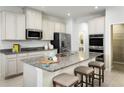 Gourmet kitchen with granite countertops, stainless appliances, and large center island with bar seating at 8917 Waxwing Way, Parrish, FL 34219