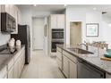 Well-equipped kitchen with stainless appliances, granite counters, and access to pantry and open living spaces at 8917 Waxwing Way, Parrish, FL 34219