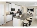 Open kitchen layout featuring an island with seating and stainless steel appliances at 8921 Waxwing Way, Parrish, FL 34219