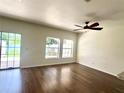 Living room featuring wood flooring, a ceiling fan, and sliding glass doors to the backyard at 930 Woodbridge Ct, Safety Harbor, FL 34695