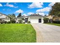 Inviting single-story home with a well-maintained lawn, long driveway, and attached two-car garage at 10093 Holly Berry Dr, Weeki Wachee, FL 34613