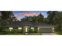 Charming single-story home with well-lit windows and manicured landscaping at dusk at 10149 Rockbay Rd, Brooksville, FL 34601