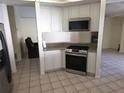 Bright kitchen with white cabinetry, stainless appliances, and tile flooring at 10244 Hoover St, Spring Hill, FL 34608