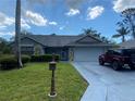 Single-story home with stone accents, and a well-manicured lawn, including an old-style letter box at 10301 Ravines Dr, New Port Richey, FL 34654