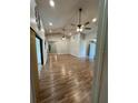 Bright living room with laminate flooring, neutral paint, vaulted ceilings, and a ceiling fan at 10301 Ravines Dr, New Port Richey, FL 34654