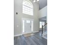 Bright foyer showcasing a modern front door, high ceilings, and stylish wood-look flooring at 10386 Norvell Rd, Spring Hill, FL 34608