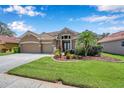 Charming home with a two-car garage, beautiful landscaping, and inviting entrance at 11726 Belle Haven Dr, New Port Richey, FL 34654