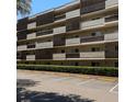 Close-up of a multi-story condo with balconies and parking lot in front at 1243 S Martin Luther King Jr Ave # C505, Clearwater, FL 33756