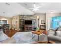 Spacious living room featuring hardwood floors, decorative brick wall, and ample natural light at 13444 English Parrot Rd, Brooksville, FL 34614