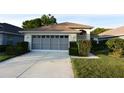 Single-story home with a two-car garage, neat landscaping, and inviting curb appeal at 14112 Whitecap Ave, Hudson, FL 34667