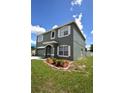 Two-story home featuring an attached garage, manicured lawn with shrubbery, and cloud-dotted sky at 15160 Durango Cir, Brooksville, FL 34604