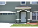 Close-up view of a two-story home's garage, arched entryway, and manicured front yard at 15160 Durango Cir, Brooksville, FL 34604
