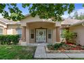 Inviting home entrance featuring a covered porch, manicured landscaping, and decorative front door at 15287 Coot Rd, Weeki Wachee, FL 34614