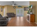 Comfortable living room featuring wood flooring, ceiling fan, and sliding glass doors to the outdoors at 15287 Coot Rd, Weeki Wachee, FL 34614