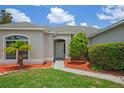 Close-up of a charming home highlighting the front door, meticulously manicured landscaping, and vibrant mulch at 15569 Burbank Dr, Brooksville, FL 34604