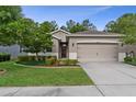 Charming single-Gathering home featuring a well-maintained lawn, mature trees, and neutral exterior paint at 17843 Garsalaso Cir, Brooksville, FL 34604