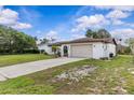Inviting single-story home featuring a long driveway and well-manicured landscaping at 2450 Ambassador Ave, Spring Hill, FL 34609