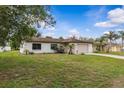Attractive single-story residence featuring an attached garage, and lush green lawn at 2450 Ambassador Ave, Spring Hill, FL 34609