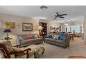 Cozy living room featuring two sofas, a ceiling fan, and a view of the dining area at 2486 Deer Trail Ln, Spring Hill, FL 34606