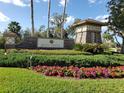 Beautifully landscaped Key Vista community sign with colorful flowers and palm trees on a sunny day at 2542 Sandy Hill Ct, Holiday, FL 34691