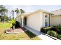 Well-maintained home exterior with lush landscaping, a charming entrance, and an arched portico at 2542 Sandy Hill Ct, Holiday, FL 34691