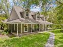 Inviting two-story home featuring a covered porch with rocking chairs and a stone pathway at 27091 Country Oak Dr, Brooksville, FL 34602