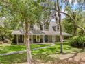 Two-story home featuring a covered porch with rocking chairs and stone pathway through the lawn at 27091 Country Oak Dr, Brooksville, FL 34602