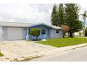 Single-story home featuring an attached garage, established landscaping, and a welcoming entryway at 3151 Wellington Dr, Holiday, FL 34691