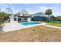 Backyard view of pool, patio, black railinged deck, and fenced yard at 4104 Pine Dale Ct, Hernando Beach, FL 34607