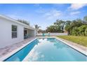 Inviting backyard featuring a sparkling pool, brick pavers, and ample space for outdoor relaxation and entertainment at 4479 Bluewater Ave, Spring Hill, FL 34606
