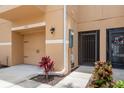 Exterior side view of a townhome unit with a garage, front door, and tidy landscaping at 5520 White Marlin Ct, New Port Richey, FL 34652