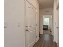 Hallway featuring wood-look flooring, white trim, and a view into the living space at 5520 White Marlin Ct, New Port Richey, FL 34652