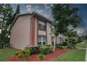 Two story home with brick trim and freshly manicured landscaping, shrubs, and trees at 6338 Spring Flower Dr # 21, New Port Richey, FL 34653