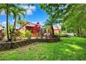 Lush backyard featuring mature trees, a well-maintained lawn, privacy fence, and tasteful landscaping at 6505 Broadwing Ct, Tampa, FL 33625