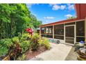 Relaxing screened patio featuring a lovely garden view and a pathway to the house at 6505 Broadwing Ct, Tampa, FL 33625