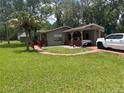 Charming single-story home with a covered carport, palm tree, and well-maintained front lawn at 717 Whiteway Dr, Brooksville, FL 34601