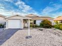 Charming single story home with a light gray exterior, attached garage, and lovely landscaping at 7303 Hatteras Dr, Hudson, FL 34667