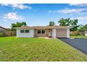 Charming single-story home featuring a well-maintained lawn and inviting curb appeal on a sunny day at 7316 Tangelo Ave, Port Richey, FL 34668