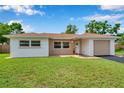Charming single-story home featuring a well-maintained lawn and inviting curb appeal on a sunny day at 7316 Tangelo Ave, Port Richey, FL 34668