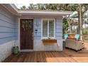 Close up of front entrance, showcasing the wood door and adjacent outdoor lounge area at 7424 Grand Blvd, New Port Richey, FL 34652
