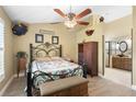 Cozy main bedroom with decorative ceiling fan, hardwood floors, and en-suite bath at 7923 Woburn St, New Port Richey, FL 34653