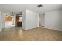 Open concept living room with tile flooring leading into the adjacent kitchen at 8053 Dedham Dr, Port Richey, FL 34668
