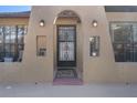 Arched entrance with secure iron gate, decorative lights, and tiled front porch at 8914 Schrader Blvd, Port Richey, FL 34668