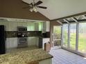 Bright kitchen with white cabinets, stainless steel appliances, and tiled floors next to sunroom at 9155 Pemberton St, Spring Hill, FL 34608
