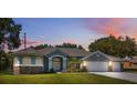 Charming single-story home with lush lawn, mature trees, and a convenient three-car garage at 9431 Amidon St, Spring Hill, FL 34608
